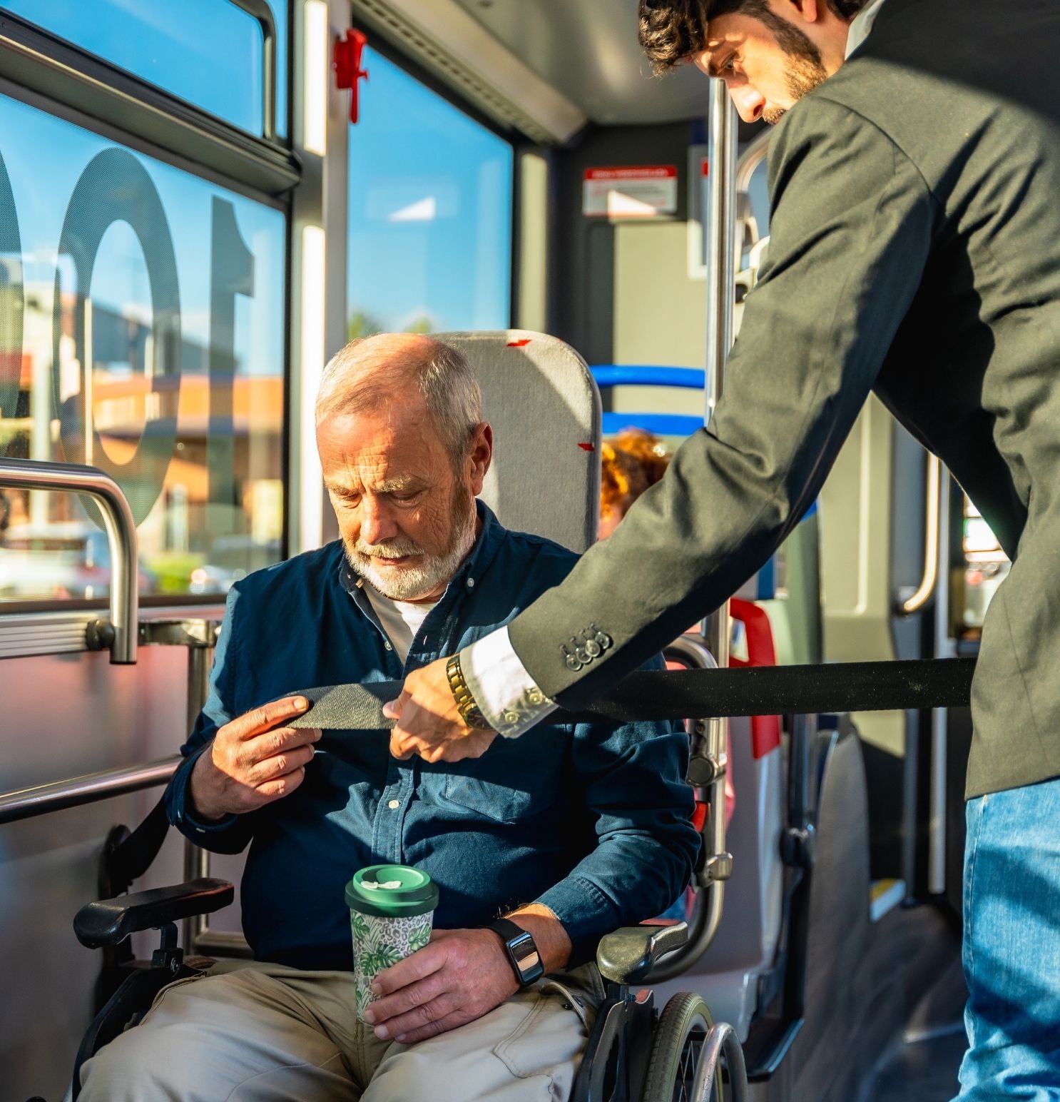 an elderly disabled man being assisted in paratransit